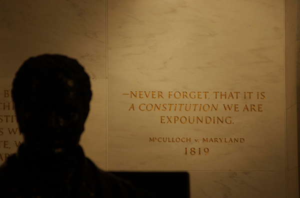 A statue of John Marshall in the foreground, with a quotation from McCulloch v. Maryland (written by Marshall) engraved into the wall, at the U.S. Supreme Court Building in Washington, D.C.