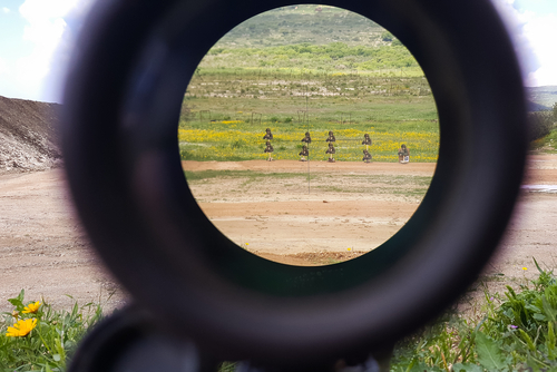 A look through an optical sight aimed at a group of potential targets at the range, outdoor shot, Israeli army IDF training zone