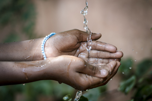 Water Spilling Into Black African Children's Hands
