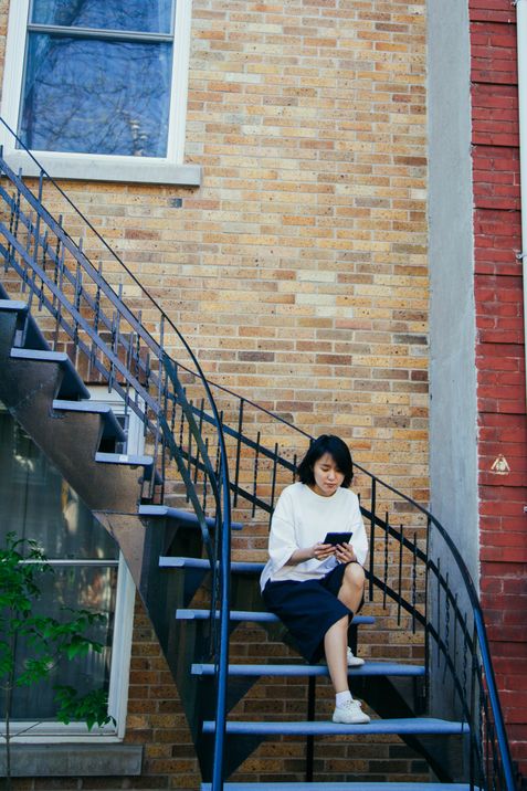 Yunjung Na reads her Kobo on the balcony before returning to Toronto from Montreal