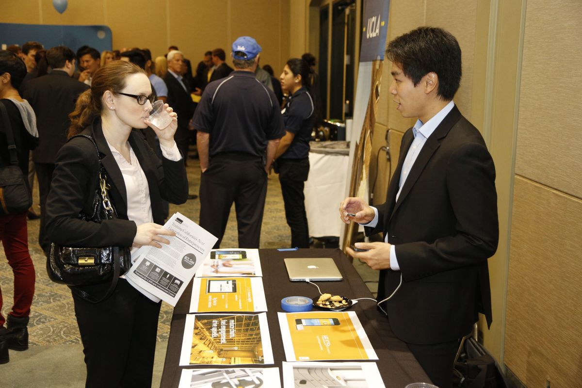 A UCLA student entrepreneur speaks with a guest about his company.