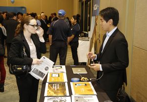 A UCLA student entrepreneur speaks with a guest about his company.