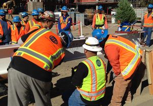 Construction workers sign the final beam before it is hoisted to the top of the Meyer and Renee Luskin Conference Center