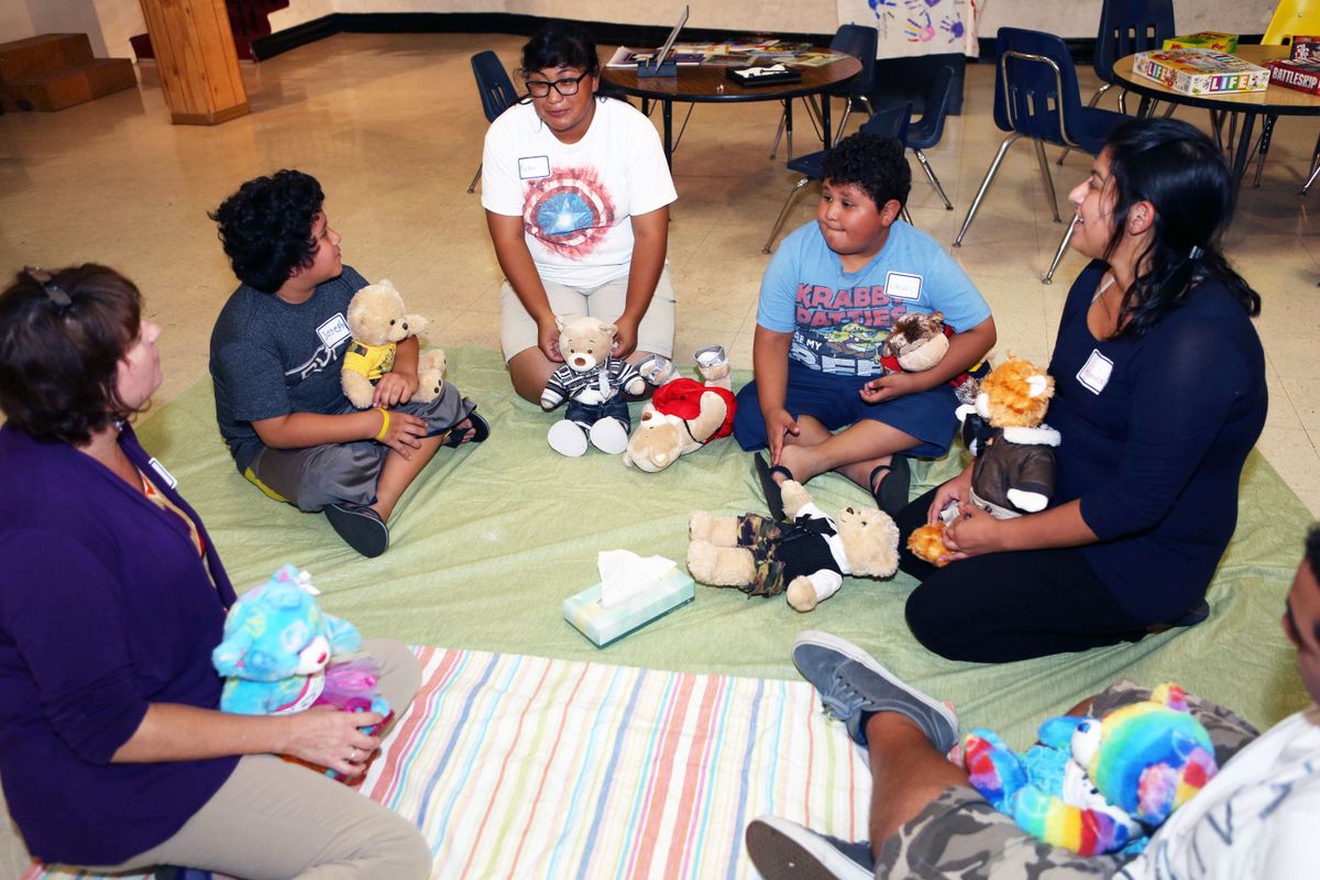 Social workers Elaine Wittert (left) and Veronica Romo (right) and family members talk about the death of a child at a meeting of the Comforting Hearts Family Bereavement Group