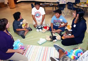 Social workers Elaine Wittert (left) and Veronica Romo (right) and family members talk about the death of a child at a meeting of the Comforting Hearts Family Bereavement Group