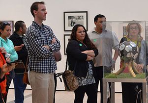 Teachers take a guided tour of a soccer exhibit at the Los Angeles County Museum of Art