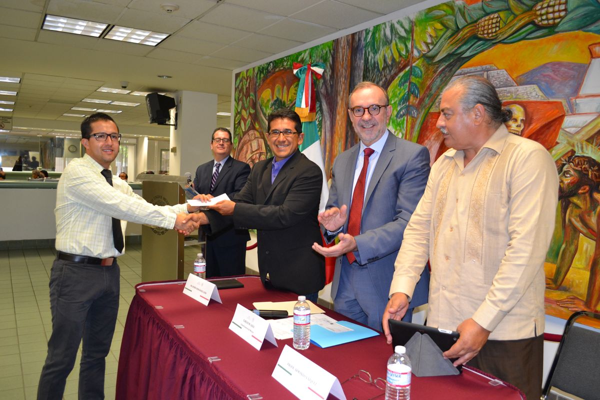Lopez-Flores receives a check from associate professor of sociology Rubén Hernández-León 