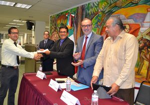 Lopez-Flores receives a check from associate professor of sociology Rubén Hernández-León 