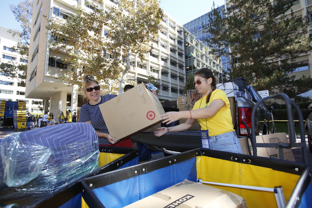 Mother and daughter unload their car.