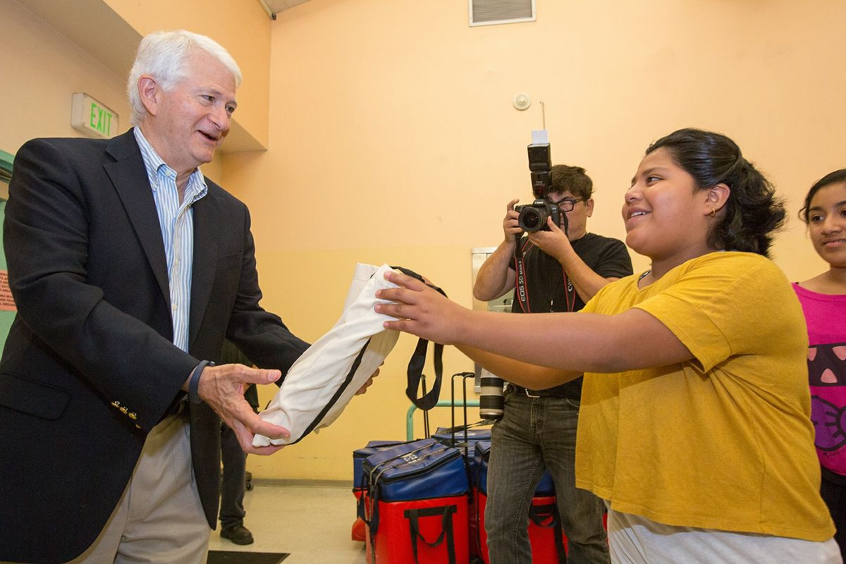 Volunteer Day 2014 Chancellor hands out a bag.