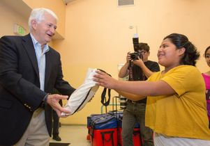 Volunteer Day 2014 Chancellor hands out a bag.