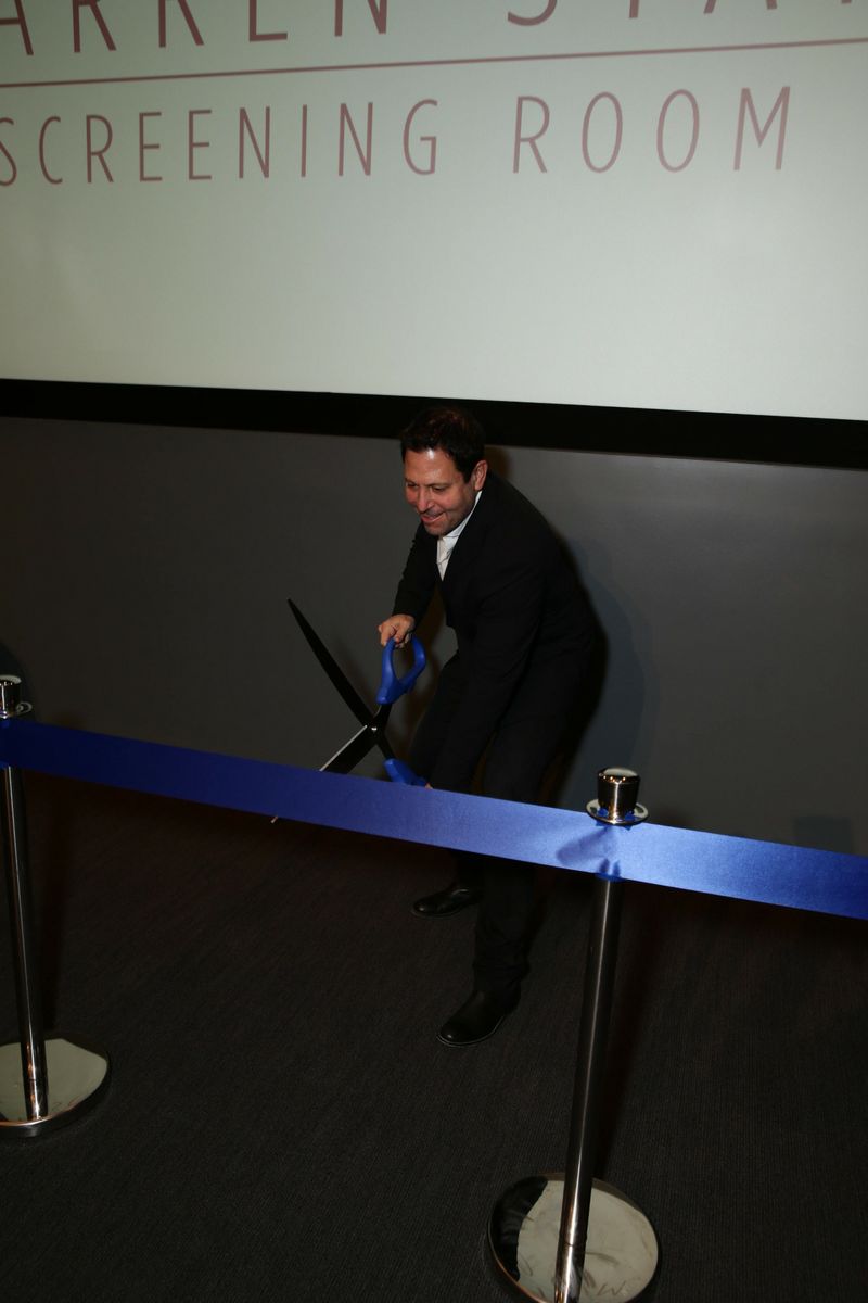 Donor Darren Star cuts a ribbon, opening the renovated screening room.