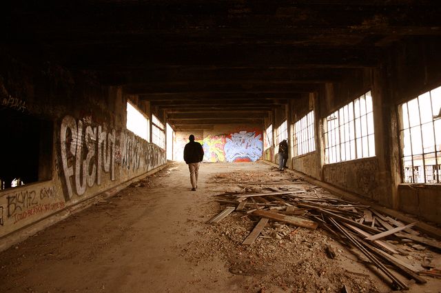 A man walks through an abandoned factory in the Midwest