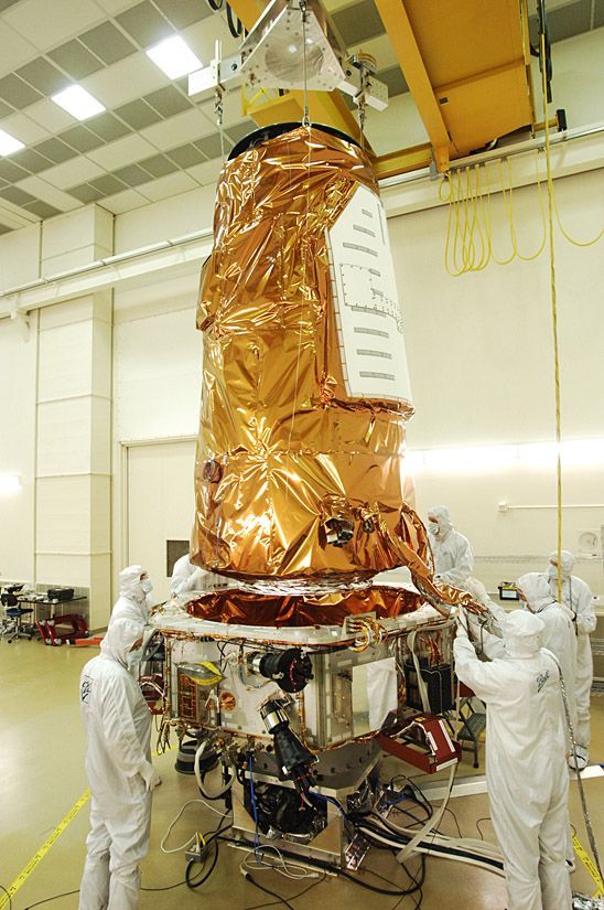 Workers lower photometer onto spacecraft