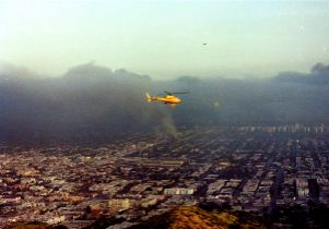 Helicopter flies over burning parts of the city