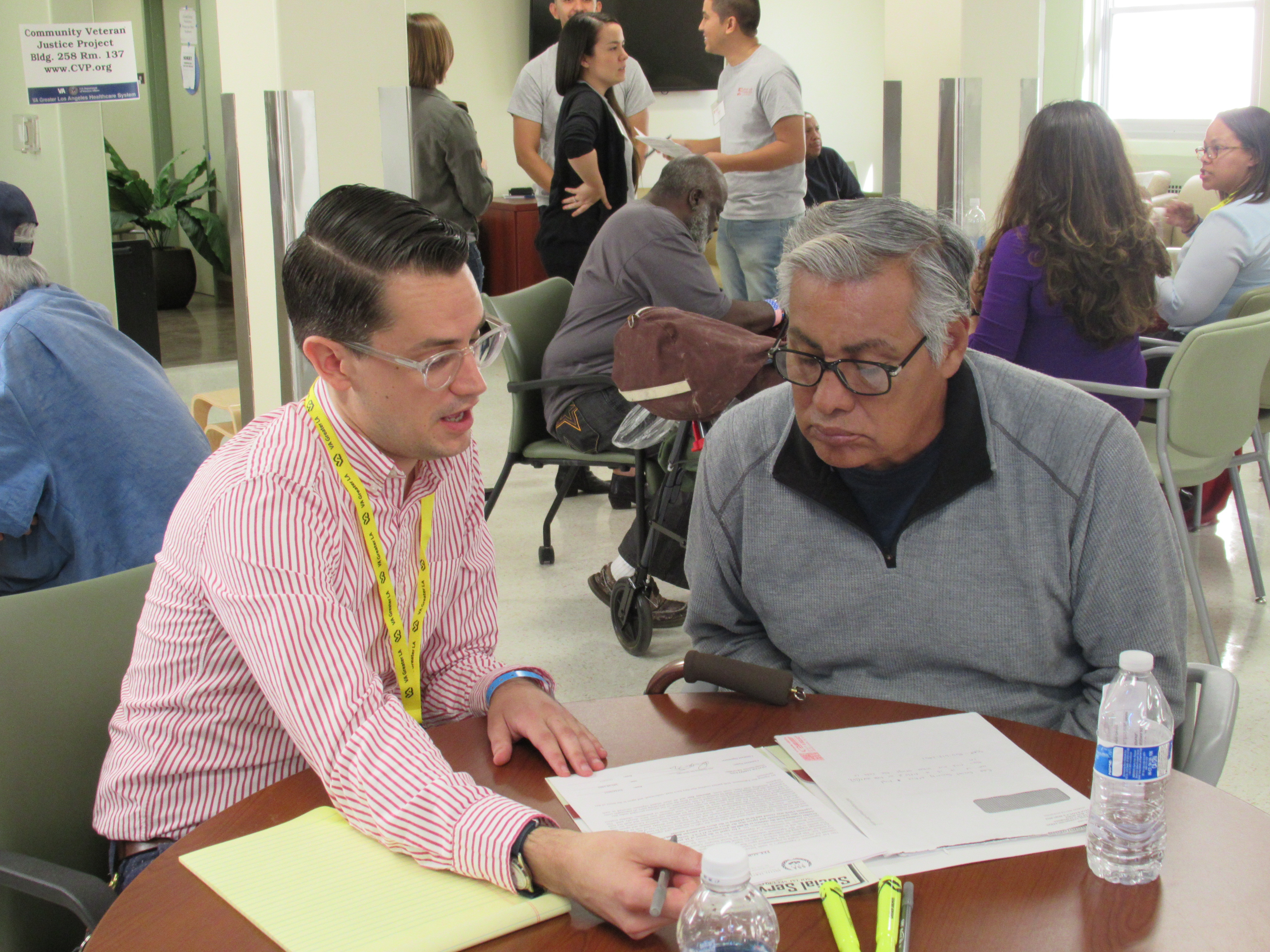 Ian Grady seated at table, working with a vet at the veterans business bootcamp
