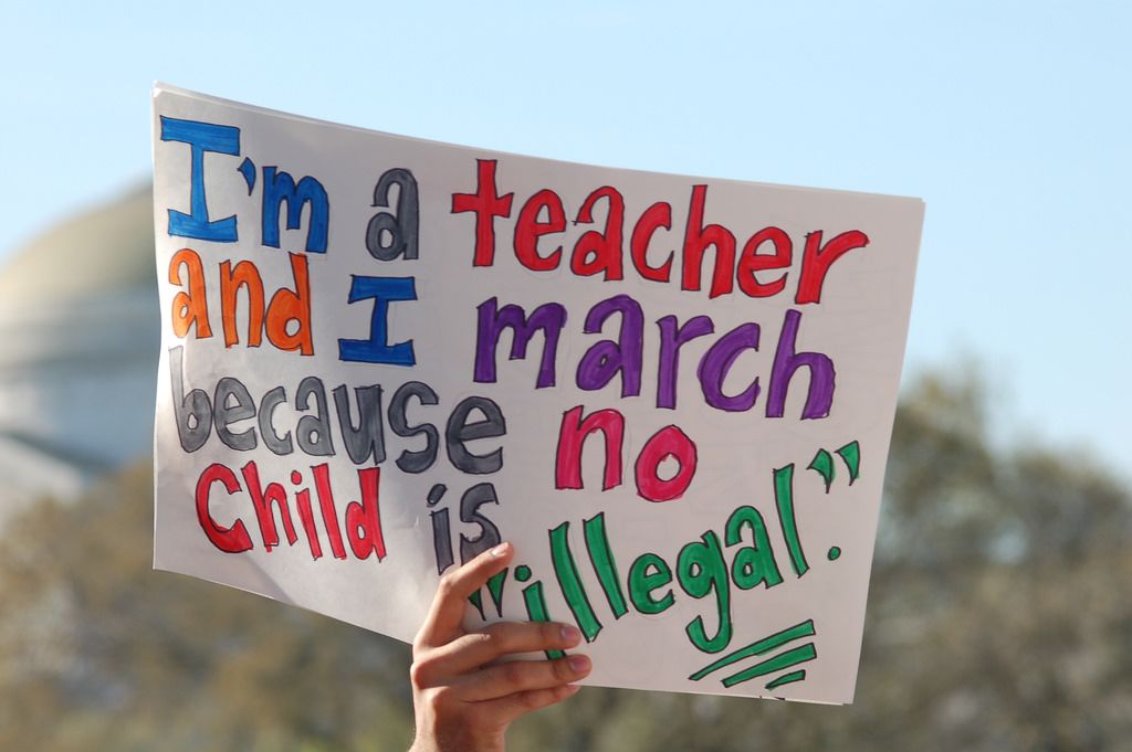 Teacher with immigration sign