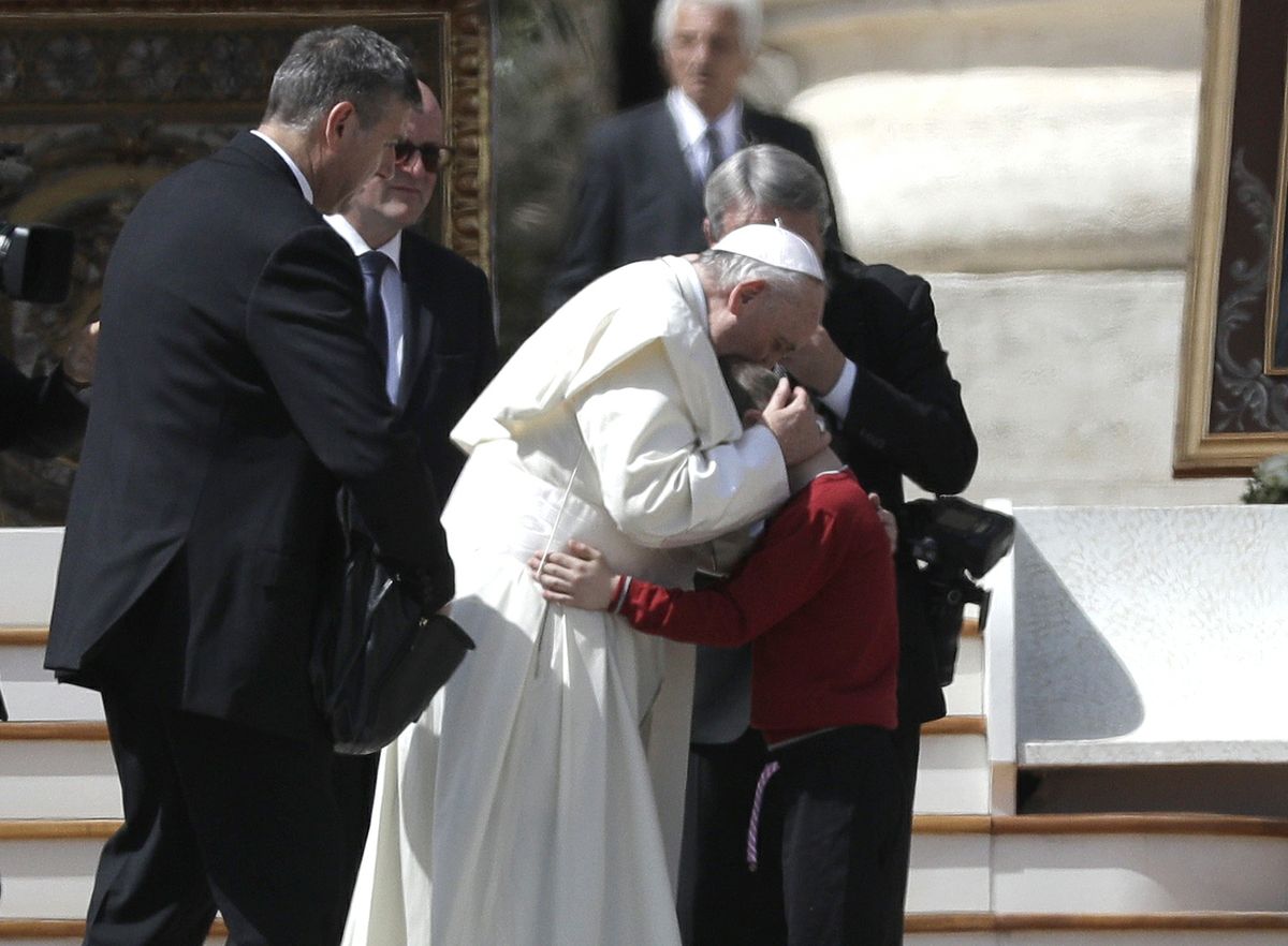 Pope hugs child