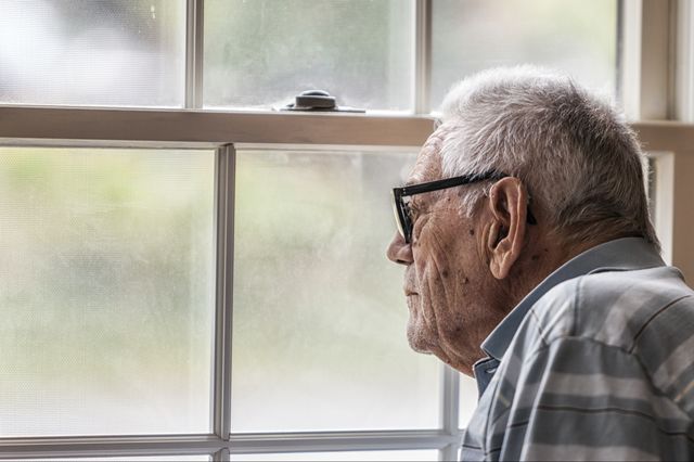 Senior man looking out window