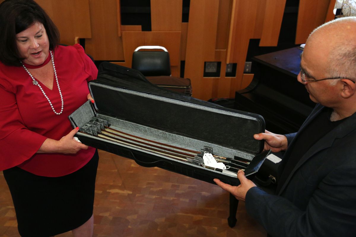 Lynn Running of the Twiford Foundation presents Professor Movses Pogossian with the violin bows that are part of the donated collection.