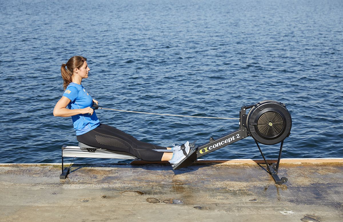 2. Hold the handle (palms on top), keep your legs straight and lean back, body angled so your shoulders are behind your hips and arms are bent close to your body, elbows up. This is called the “finish.” Quick Take Rowing 2