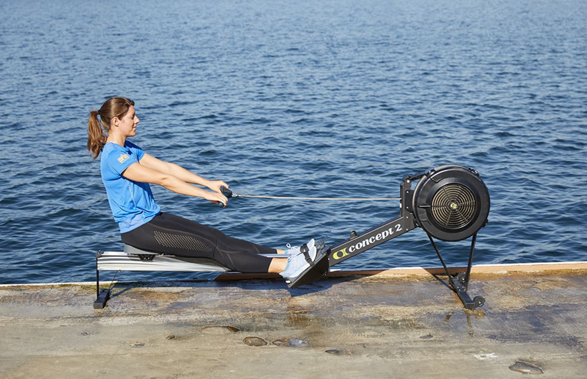 5. At the catch, engage your core, quads and glutes, and drive your knees down, pushing with your legs. Keeping your arms straight, work your torso off your legs, and swing your torso back. Quick Take Rowing 5