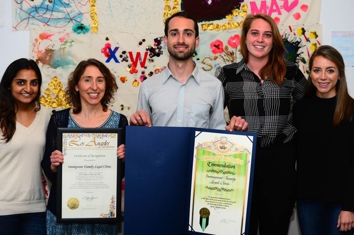 Members of legal clinic holding commendations