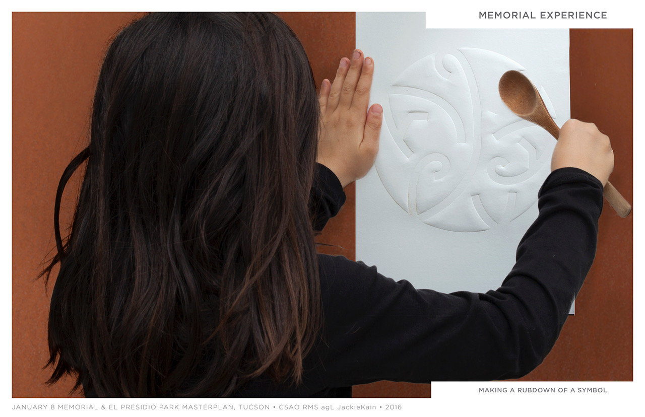 A child makes a rubbing of one of the symbols designed by Rebeca Méndez for the Jan. 8 Memorial.