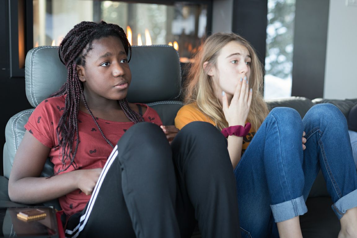 Two teen girls watching television