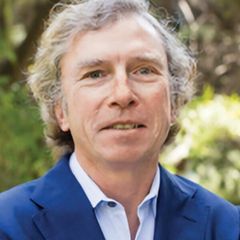 Headshot of Michael Jerrett wearing a blue blazer, photographed outdoors.