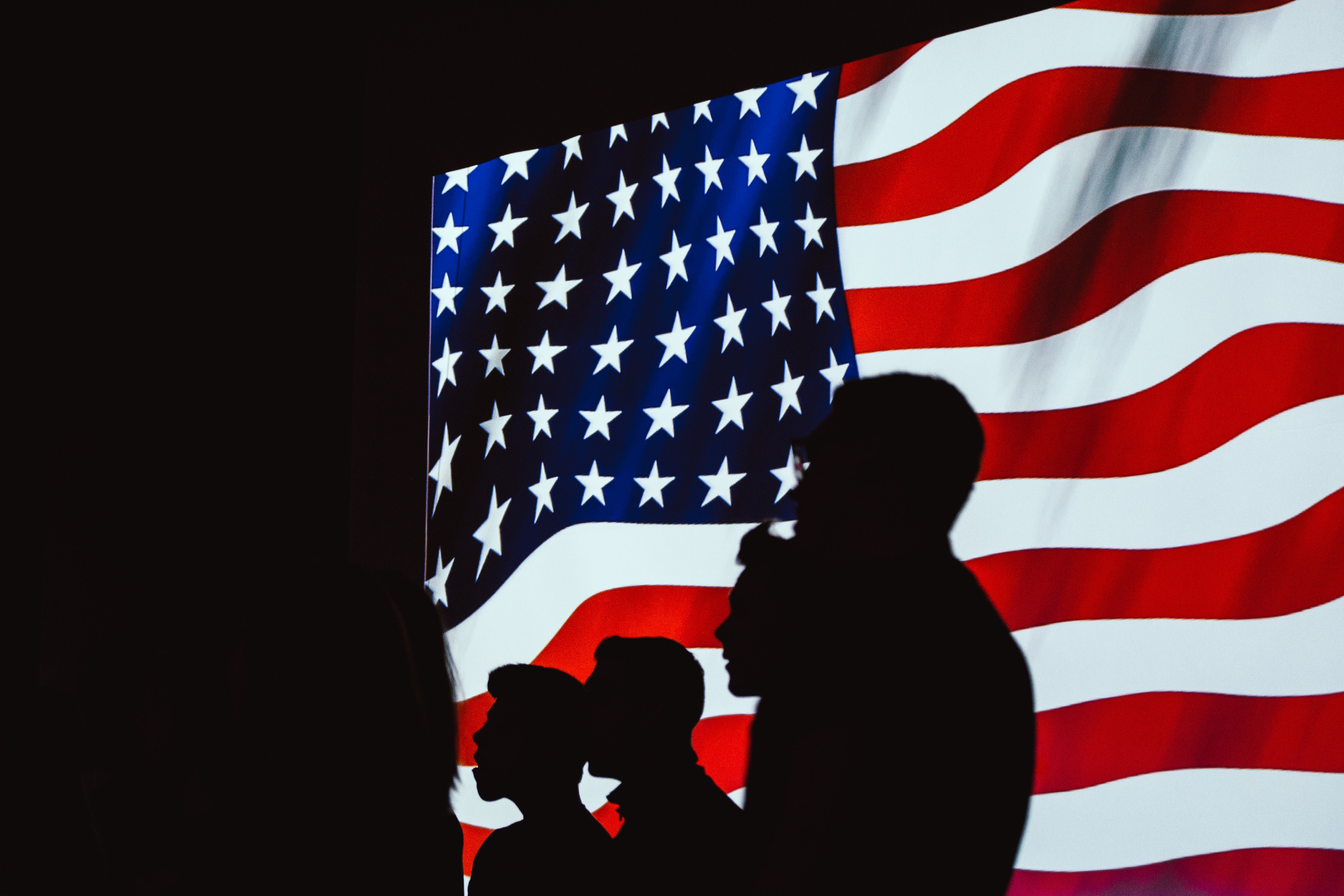 Scene from Kenneth Wells' opera with American flag and silhouetted soldiers