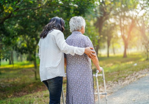 Caregiver helps older woman with walker