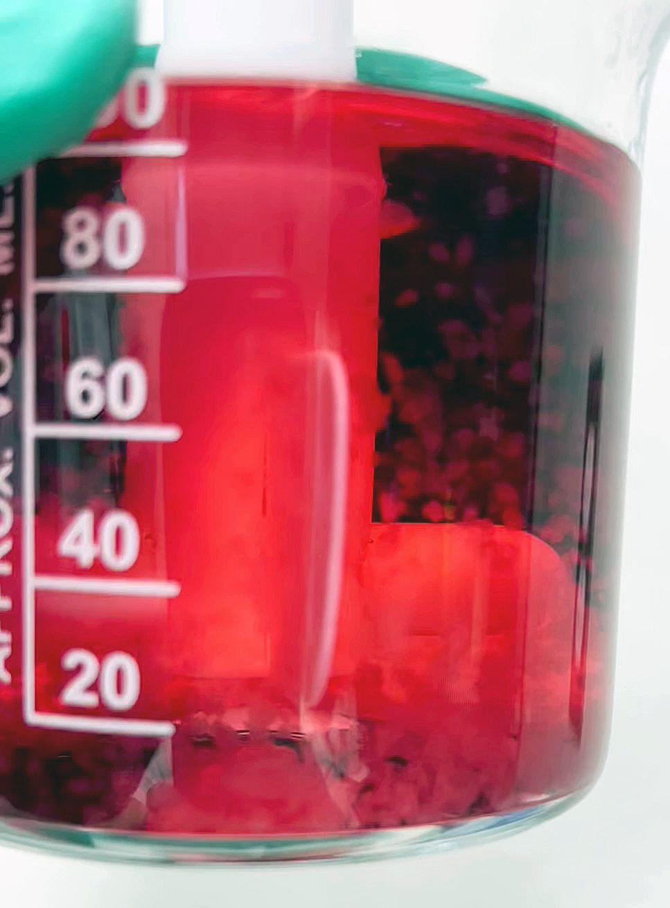 Cells suspended in red liquid in a jar