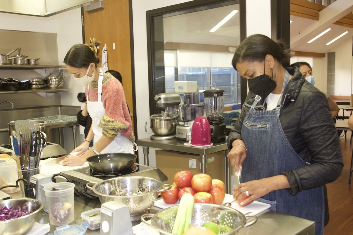 Two women preparing food in the UCLA teaching kitchen