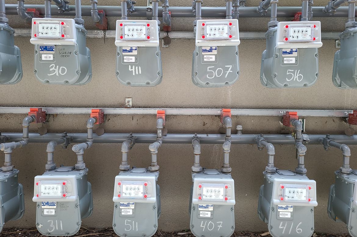 Two rows of utility meters outside of a residential building