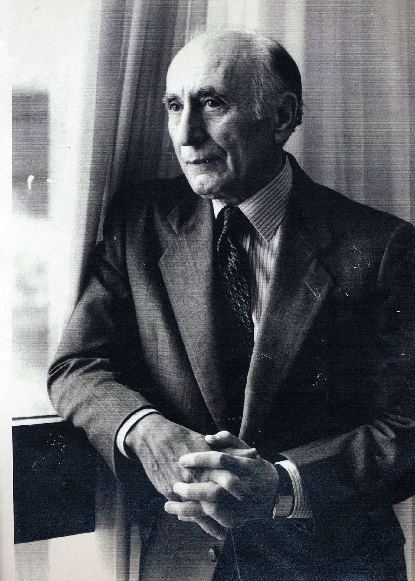 Black-and-white photo of Ehsan Yarshater standing by a window