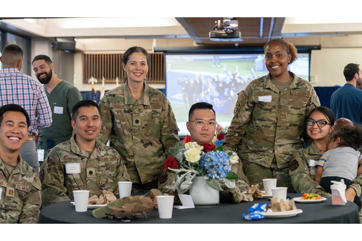 Six UCLA military service members in fatigues seated at luncheon table