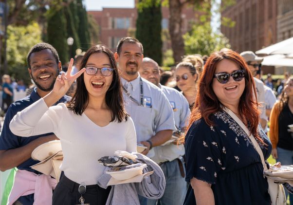 Smiling staffers standing in line at the picnic 
