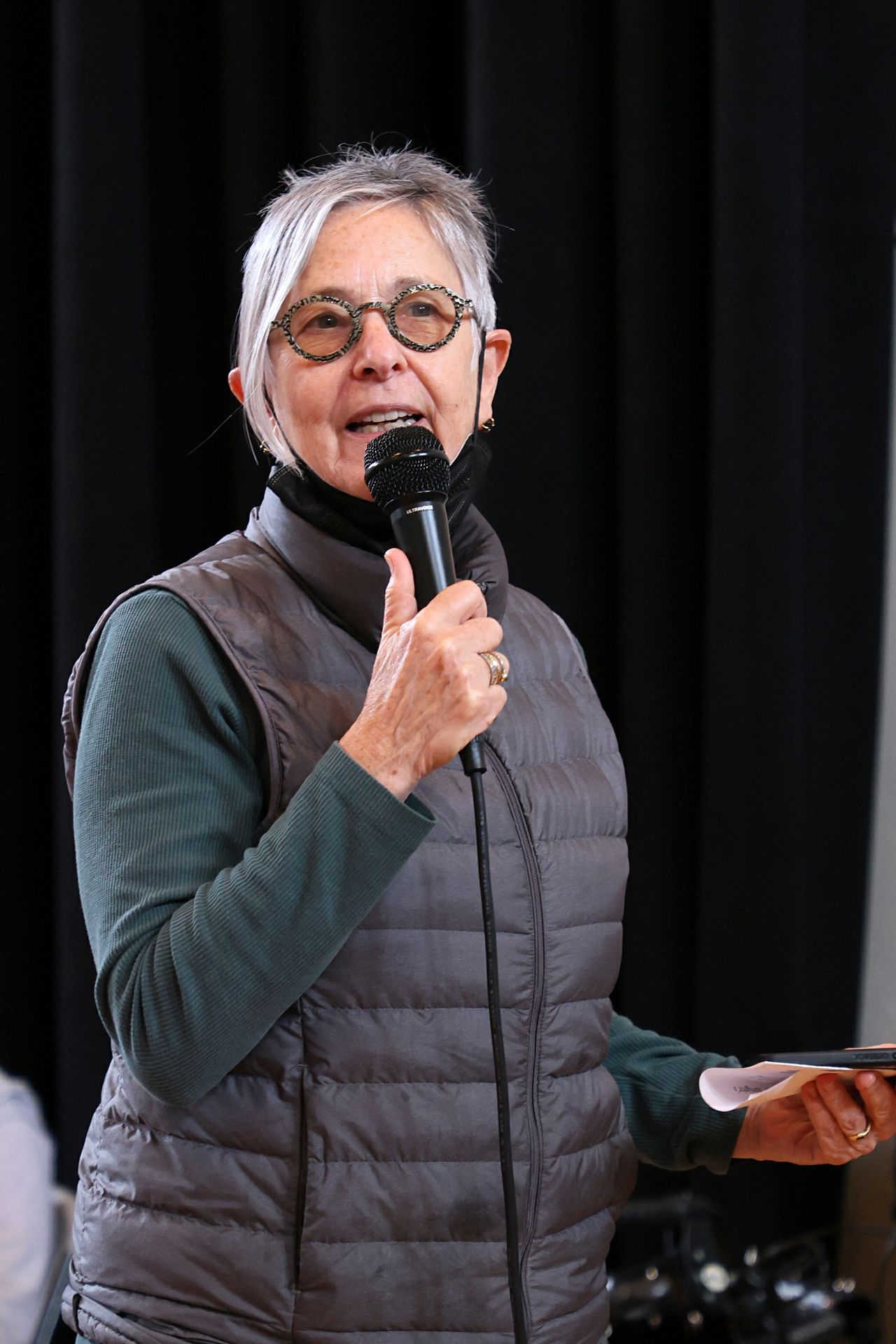Victoria Marks wearing a puffer vest and speaking into a microphone
