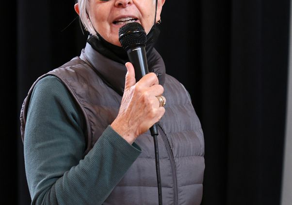 Victoria Marks wearing a puffer vest and speaking into a microphone