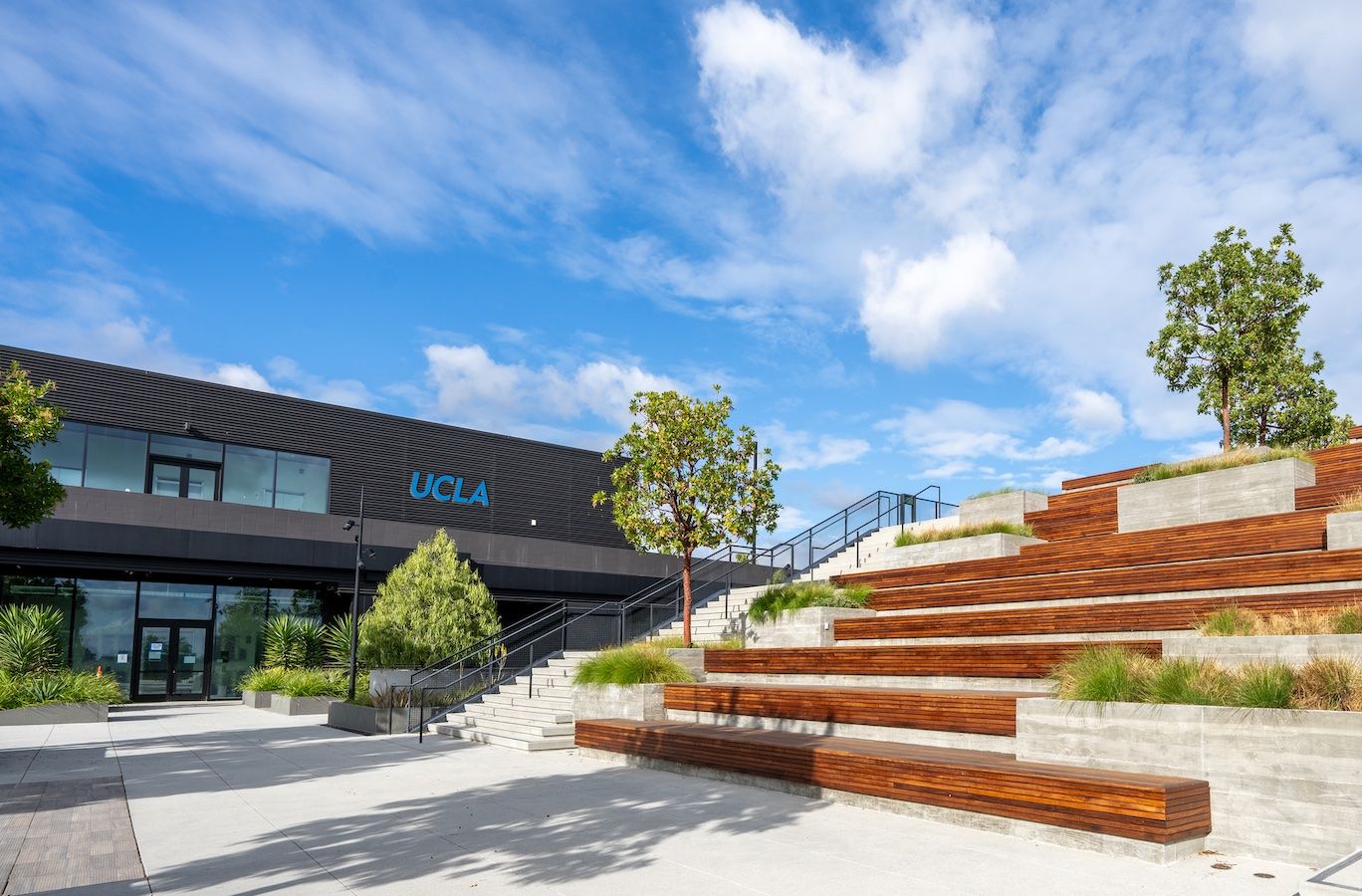 View of a portion of the building from outside, with terraced wood and cement benches in the foreground