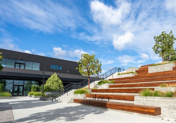 View of a portion of the building from outside, with terraced wood and cement benches in the foreground