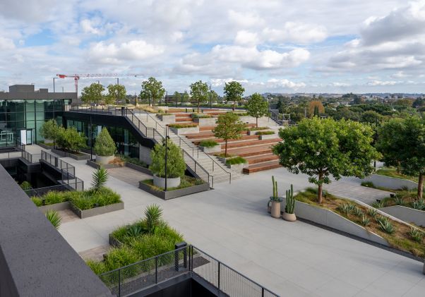 Wide shot of back of properties with patio, terraced benches and construction crane