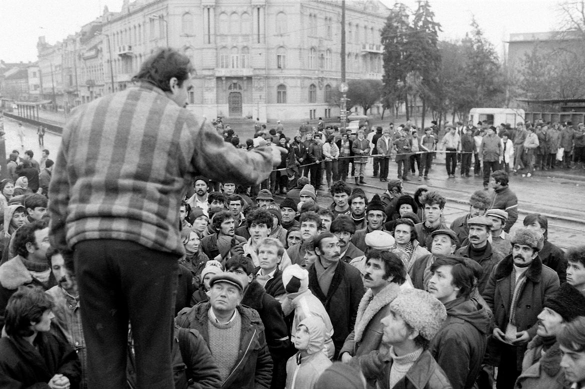 Black-and-white photo of speaker addressing crowd during Romanian Revolution