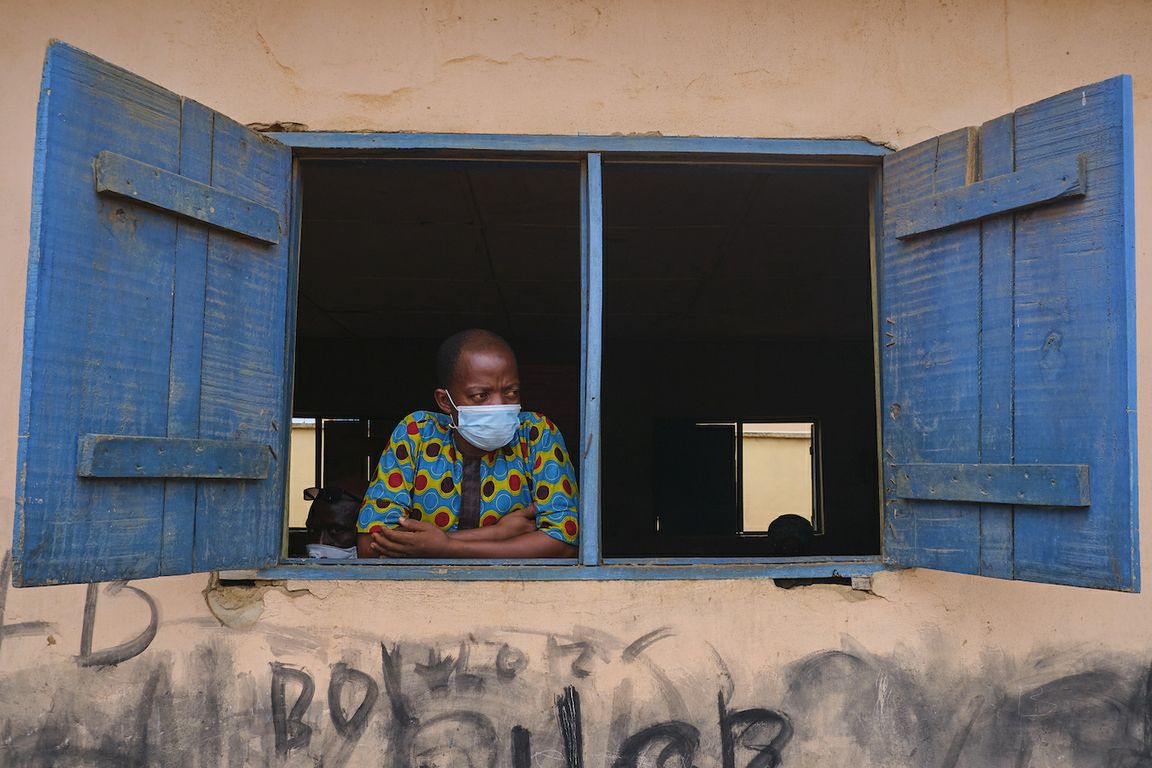 Man wearing a Covid-19 mask looks out from window in Lagos, Nigeria