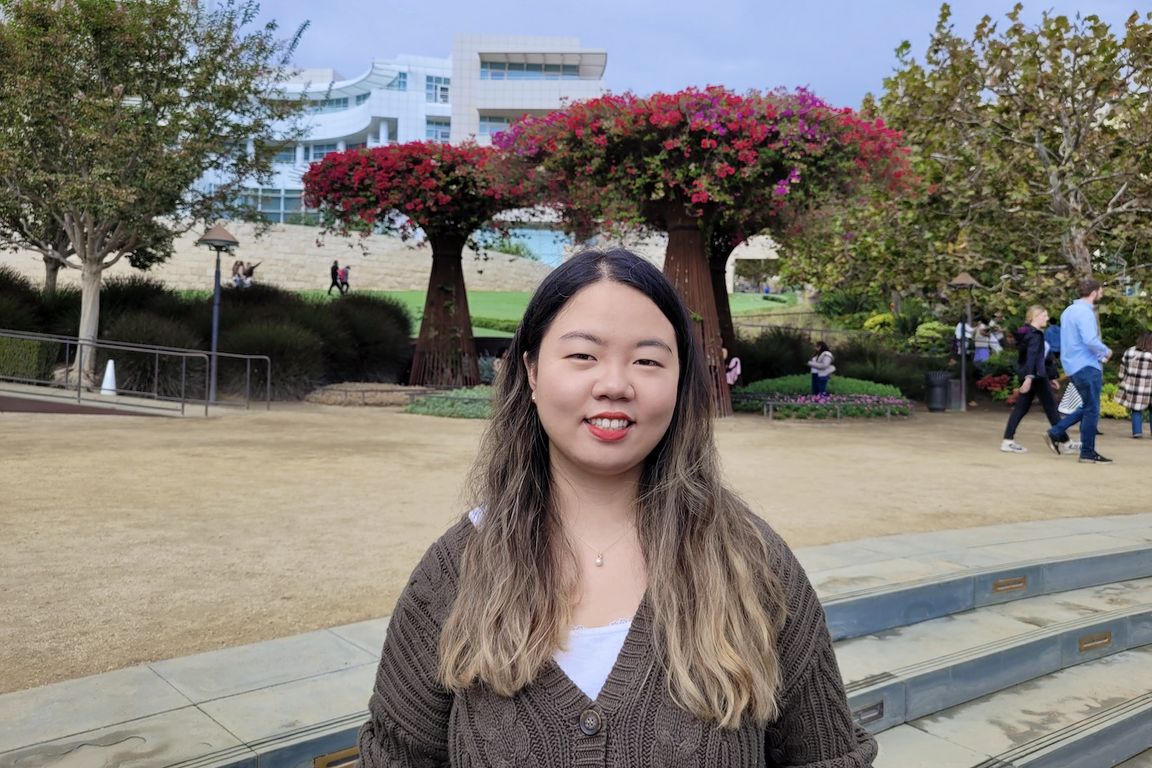 Gloria Jiyoon Kim at the Getty Center, with trees and building in the background