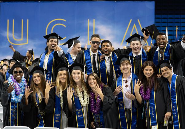 Graduates giving fours-up sign at UCLA College commencement 