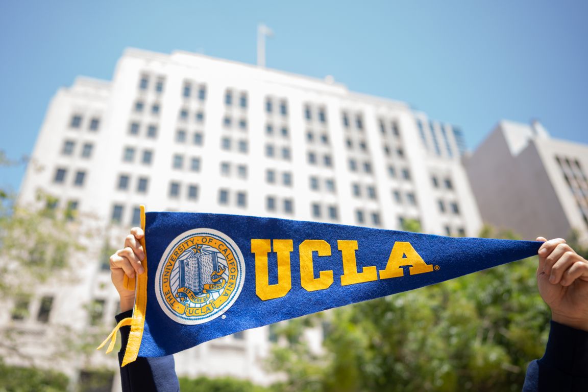 Hands holding banner in front of the downtown Trust Building