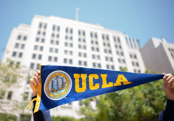 Hands holding banner in front of the downtown Trust Building