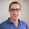 Headshot of David Eisenman wearing glasses and a blue shirt.
